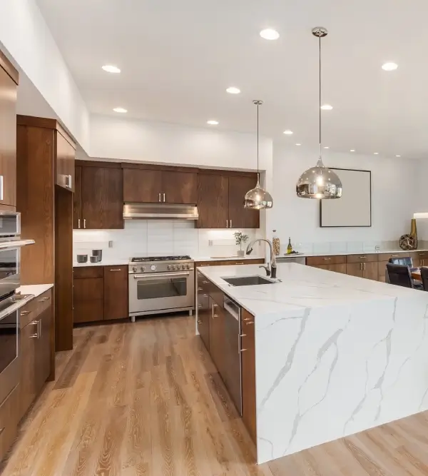 Modern kitchen with white marble countertops and dark wood cabinets