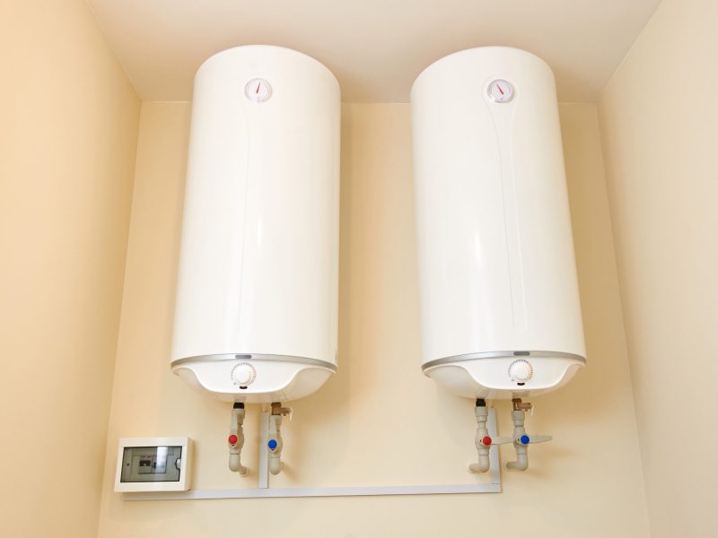 Two electric water heaters on the wall. Home wall mounted two water heating boilers. No people.